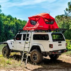 a white jeep with a red tent on the roof