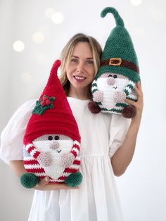 a woman holding two crocheted christmas gnomes