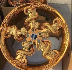 two gold dragon wheels are sitting in a box