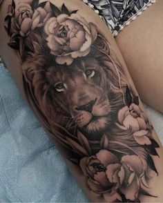 a woman's thigh with a lion and flowers on it