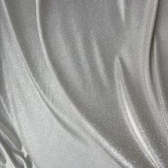 Make a statement with this shimmery silver Lurex Glitter Fabric! This luxurious fabric is perfect for creating stunning gowns, apparel, costumes, party wear, and more. The grey lurex has a two-tone palette/ iridescent look, and is full of glitter, giving it a beautiful shine and sparkle. It stretches on the width side only, and drapes gorgeously, sure to stand out at any event with its beautiful sparkles. The back side of the fabric is white, and made of lurex polyester. Our photographs are as a Metallic Sequin Fabric With Shimmer For Evening, Metallic Sequin Fabric With Shimmer For Wedding, Metallic Shiny Sequin Fabric For Evening, Silver Sequin Fabric For Wedding, Metallic Shimmer Sequin Fabric For Wedding, Shiny Metallic Sequin Fabric For Evening, Metallic Shimmer Sequin Fabric For Evening, Elegant Silver Sequin Fabric For Party, Silver Glitter Sequin Fabric For Wedding