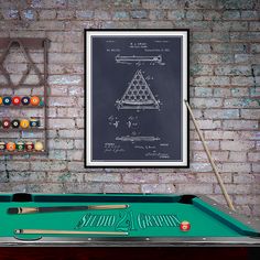 a pool table with billiards and cues in front of a chalkboard drawing