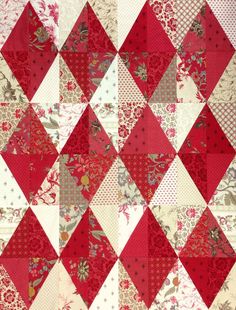 a red and white quilt with flowers on it