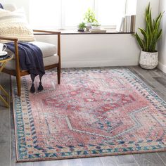 a living room area with a rug, chair and potted plant