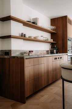 a kitchen with wooden cabinets and shelves filled with dishes on top of counter tops next to a dining room table