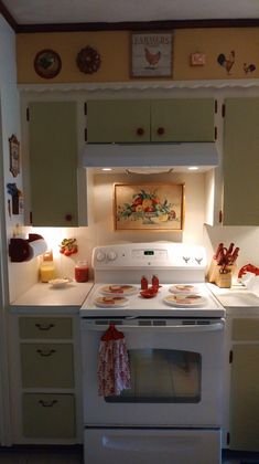 a white stove top oven sitting inside of a kitchen