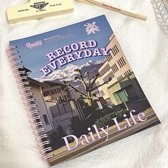 a book sitting on top of a bed next to a pen