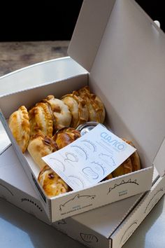 two boxes filled with pastries sitting on top of a table