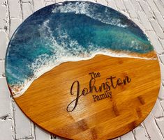 a wooden plaque with the words, the johnston family on it in front of an ocean wave