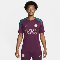 a young man wearing a purple and green soccer jersey with the words qatar airways on it