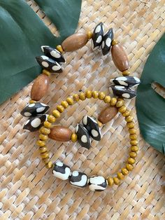 Welcome to our Bohemian Stretch Bracelets - a delightful fusion of earthy textures and vibrant patterns that will add a touch of free-spirited charm to your ensemble! 🌿✨ Each bracelet in this set is handcrafted with care and attention to detail, featuring a unique combination of 5mm round wood beads, large cylinder beads, polka dot African bone beads, and batik swirl African bone beads. These beads come together to create eye-catching designs that exude bohemian flair and individuality. Measuri Traditional Wooden Beads Bracelets For Beach, Bohemian Brown Beaded Bracelets With Oval Beads, Adjustable Yellow Bracelet With Wooden Beads, Bohemian Yellow Stretch Bracelet With Large Beads, Yellow Wooden Beads Bracelet, Yellow Wooden Bead Bracelets, Adjustable Yellow Wooden Beaded Bracelets, Brown Bracelets With Large Beads For Festival, Yellow Bracelet With Round Wooden Beads