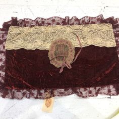 a piece of cloth with lace on it and a tag attached to the side of it