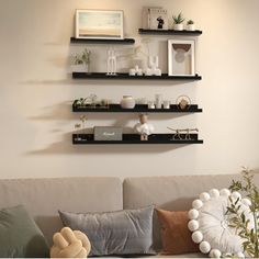 a living room filled with lots of furniture and shelves on the wall above it's couch