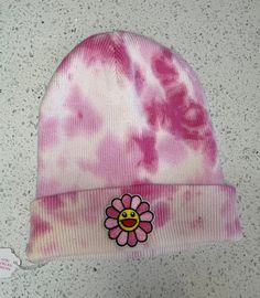 Murakami beanie! This hat magically fits adults and kids and looks adorable on everyone! The hat is dyed with shades of pink and topped off with a pink Murakami flower smiley face patch.  This item has been washed twice, before and after the dying process. Procion fiber reactive dyes are typically color-fast, however, I advise that you wash this freshly-dyed item separately for the first few washes. Pink Murakami Flower, Flower Smiley Face, Smiley Face Patch, Flower Smiley, Murakami Flower, Face Patches, Tie Dye Outfits, Hanukkah Gifts, Body Pillow Covers