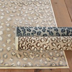 a leopard print rug is laying on the floor next to a cat scratch mat and scratching pad