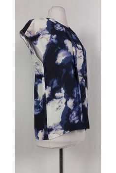 This casual top is made with an eye-catching abstract print. Pleated front and keyhole back add a feminine touch. Great for a day of errands, this top can be paired with skinny jeans and flats. Size 8 100% viscose Rounded neckline Short sleeve Slips on Pleated front Bust 38" Shoulder to hem 25.5" Chic Blue Top With Abstract Print, Trendy Blue Top With Abstract Print, Trendy Blue Abstract Print Top, Blue Printed Tops For Work, Printed Blue Tops For Workwear, Blue Abstract Print Tops For Summer, Modern Abstract Print Tops For Spring, Blue Graphic Print Top For Work, Chic Blue Top With Graphic Print