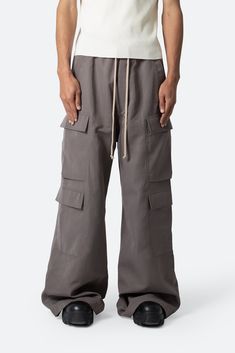 the Rave Double Cargo Pants are designed with a new oversized rave fit, constructed from a polyester fabric with a rinse wash, contrast drawcord, and finished with cargo pockets throughout. details ultra baggy fit throughout 100% polyester extended inseam model is 6’1, 140 lbs and wears a size 30 Brown Pants Men, Rave Fit, Dusty Brown, 140 Lbs, Streetwear Essentials, Suede Pants, Hiking Sneakers, Slim Denim, Faux Leather Pants