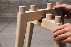 a person playing with wooden pegs on a chair outside in the day time,