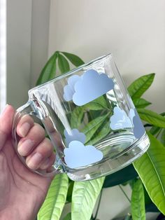 Serve your next drink from this cute cloud cup! This adorable 13 oz (384 ml) glass mug is perfect any beverage - sodas, iced coffee, or anything really! It's the perfect gift for birthdays, house warming or for any other any occasion! Glass Mug Care * Hand wash ONLY * Do not soak  * Dry with soft towel * Do not put in microwave NOTE: Since the designs on these cups are made with permanent vinyl, which is essentially a sticker. These designs are not meant to last forever, the longevity is based o Rain Cloud Mug, Glass Drinking Cups, Cute Cups And Mugs, Clear Mugs With Vinyl, Cute Coffee Mugs Designs, Cup Decoration Ideas, Glass Mugs With Vinyl, Cricut Glass Cups, Cute Mug Designs