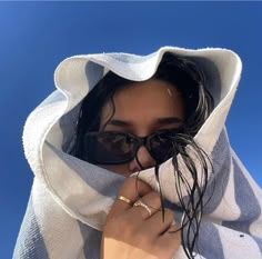 a woman with sunglasses and a towel covering her face