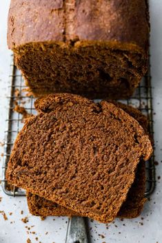 a loaf of brown bread sitting on top of a cooling rack