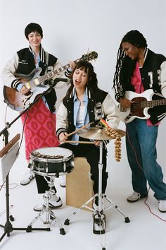 three young people are playing instruments together