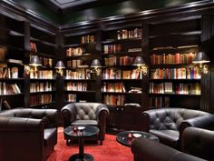 the library is full of books and leather furniture