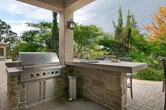 an outdoor kitchen with stainless steel appliances and grill