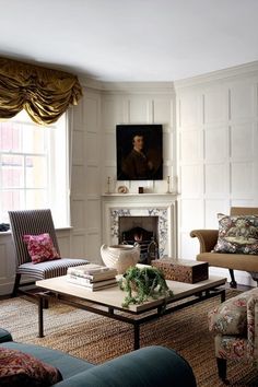 a living room filled with furniture and a painting on the wall above a fire place