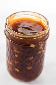 a jar filled with sauce sitting on top of a table