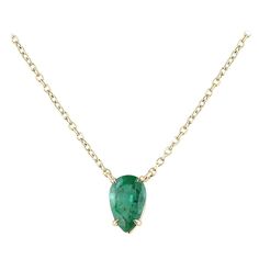 The solitaire pear-cut necklace is a stunning piece of jewelry that features a single emerald stone in a simple four prong setting. The emerald has a medium dark green color that adds to its elegance and beauty. The pendant is attached to a dainty cable chain that is adjustable from 16-18 inches, making it versatile and easy to wear with different necklines. The tip of the pear-shaped emerald faces down, adding to the unique design of the necklace. The pendant is stationary, ensuring that the st Different Necklines, Dark Green Color, Emerald Stone, Pear Cut, Cable Chain, Pear Shaped, Timeless Pieces, Prong Setting, Green Color