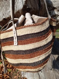 These individually woven colourful bags were woven by women in certain regions of Kenya https://en.wikipedia.org/wiki/Kiondo. The weaving skills were handed down from mothers and grandmothers. This bag has interwoven colours of shades of brown and beige. This bag is unique and is the only one of it's kind in the world. Handwoven Leather Bucket Bag In Natural Color, Weaved Bucket Bag, Handwoven Leather Bucket Bag, Natural Leather Woven Bucket Bag, Natural Leather Handwoven Crochet Bag, Woven Leather Basket Shoulder Bag, Handwoven Leather Tote Crochet Bag, Handwoven Leather Crochet Tote Bag, Multicolor Woven Tote Shoulder Bag