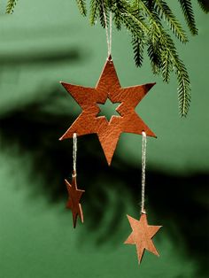 three wooden stars hanging from a christmas tree