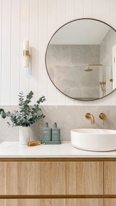 a bathroom with a round mirror above the sink