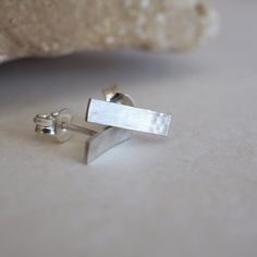 These bar delicate and lovely studs are so lightweight ideal to wear every day. ➽DESCRIPTION They are made of sterling silver textured by my hammer and a satin finish which gives a discreet brightness to your style. Sterling silver push backs included. Length:12mm (0.5'') Width:3mm ➽IMPORTANT All of my jewelry is handcrafted so please expect some small variations from the earrings on the picture. ➽IS IT A GIFT? The earrings come in a beautiful gift box ready for gift giving and ship within safe Handmade Sterling Silver Linear Earrings Gift, Minimalist Sterling Silver Earrings With Silver Clasp, Dainty Faceted Sterling Silver Earrings, Nickel-free Minimalist Sterling Silver Wrap Earrings, Dainty Sterling Silver Diamond-cut Earrings, Silver Bar Earrings, Organic Jewelry, Garnet Pendant, Waterproof Jewelry