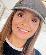 a woman wearing a hat and smiling at the camera