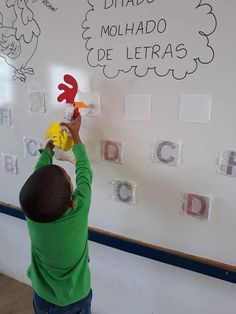 a young boy is playing with magnets on the wall