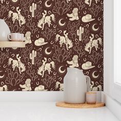 the wallpaper in this kitchen is brown with white horses and cactuses on it