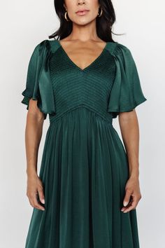 Our Lovell Smocked Midi Dress in emerald is a beautiful staple dress for your wardrobe! This pretty dress can be dressed up or dressed down! The perfect dress for any occasion! Elegant Smocked Dress With Ruched Empire Waist, Elegant Smocked Dress With Ruched Detail And Empire Waist, Elegant Green Dress With Smocked Bodice, Elegant Smocked Dress With Flutter Sleeves, Elegant Midi Dress With Smocked Back And Ruffle Sleeves, Elegant Green Midi Dress With Smocked Bodice, Green V-neck Smocked Ruched Dress, Green V-neck Smocked Dress With Ruched Details, Green V-neck Midi Dress With Smocked Bodice