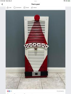 a red and white air conditioner sitting on top of a floor next to a wall