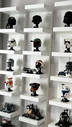 a display case filled with lots of different types of helmets on top of white shelves