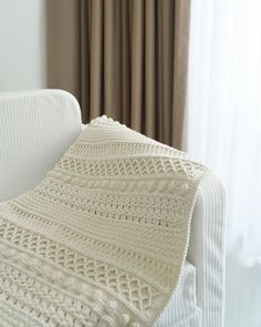 a crocheted blanket draped over a white couch