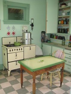 an old fashioned kitchen with checkered flooring and green cabinetry on the walls