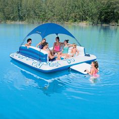 a group of people riding on the back of a blue boat in a body of water