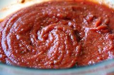 a bowl filled with red sauce sitting on top of a table