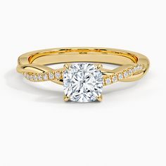 a yellow gold engagement ring with a round cut diamond in the center and side stones