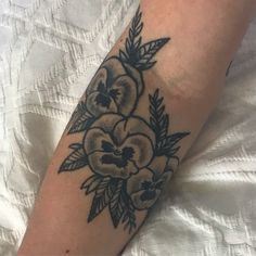 a woman's arm with black and white flowers on it