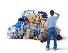 a man standing in front of a pile of clothes with his back to the camera