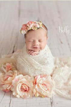 a baby wrapped in a blanket with flowers on it