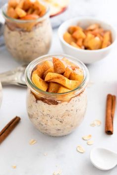 two jars filled with oatmeal and cinnamons on a table next to spoons